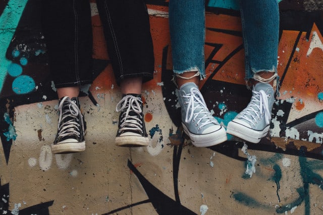 Teenager auf einer Mauer mit Graffiti (c) Unsplash | Aedrian