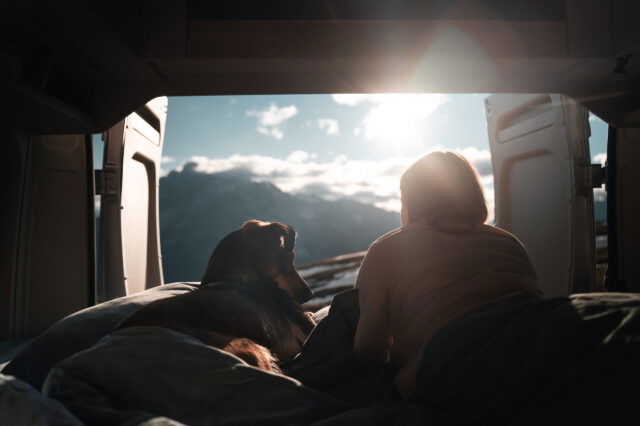 Blick aus dem Camper mit Hund und Frau