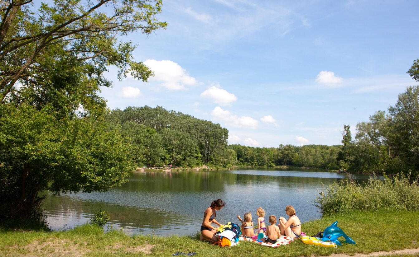 eine Familie beim Sonnen an der Dechantlacke in der Lobau in Wien