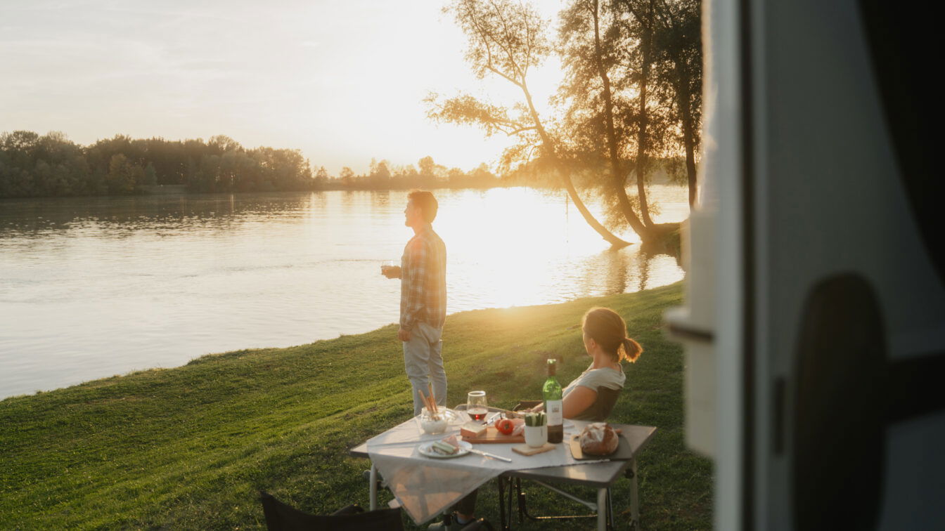 Foto Oberösterreich Tourismus GmbH/CM Visuals: Eine Frau und ein Mann am Abend beim Camping an der Donau in der Donauregion.