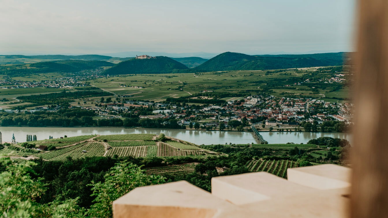 (c) Katharina Tesch | 1000things Panoramablick von der Donauwarte in Krems über die Weinberge, die Donau und die Altstadt bis zur Stiftsanlage Göttweig – idyllische Landschaft in der Wachau, UNESCO-Weltkulturerbe in Niederösterreich.