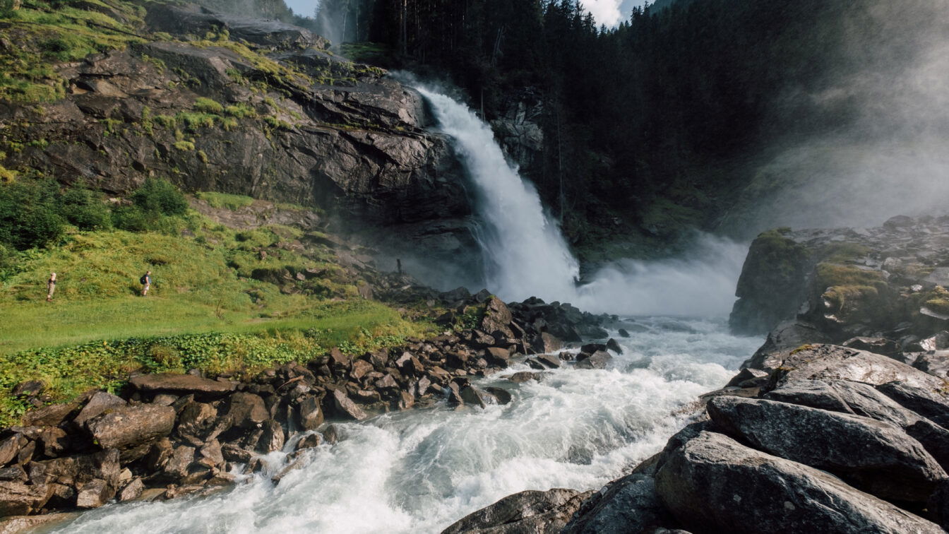 (c) SalzburgerLand Tourismus Tosende Wassermassen bei den Krimmler Wasserfällen. Zu sehen sind auch Kinder, die zum Wasserfall wandern