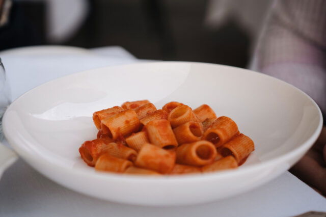 Teller mit klassischer italienischer Rigatoni Pasta in fruchtiger Tomatensauce, serviert im eleganten Ambiente von Harry’s Bistrò