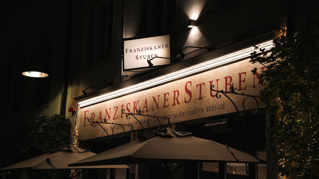 (c) Julia Riedesser | 1000things Das Bild zeigt die Franziskaner Stuben in Bozen bei Nacht