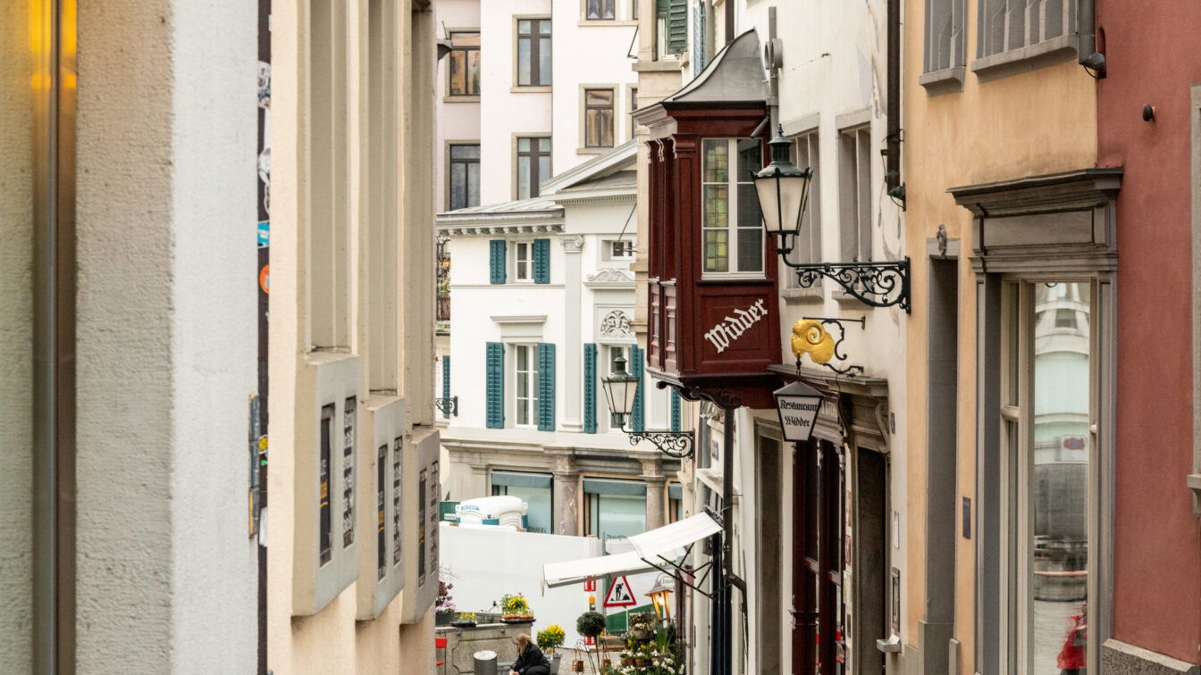 (c) Sonja Koller | 1000things Enge Altstadtgasse in Zürich mit Blick auf traditionelle Gebäude und das bekannte Restaurant Widder – beliebtes Ziel für Feinschmecker in der Zürcher Innenstadt.