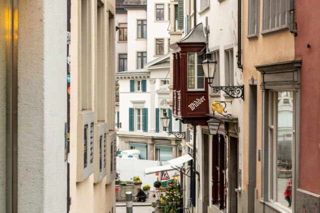 Enge Altstadtgasse in Zürich mit Blick auf traditionelle Gebäude und das bekannte Restaurant Widder – beliebtes Ziel für Feinschmecker in der Zürcher Innenstadt.