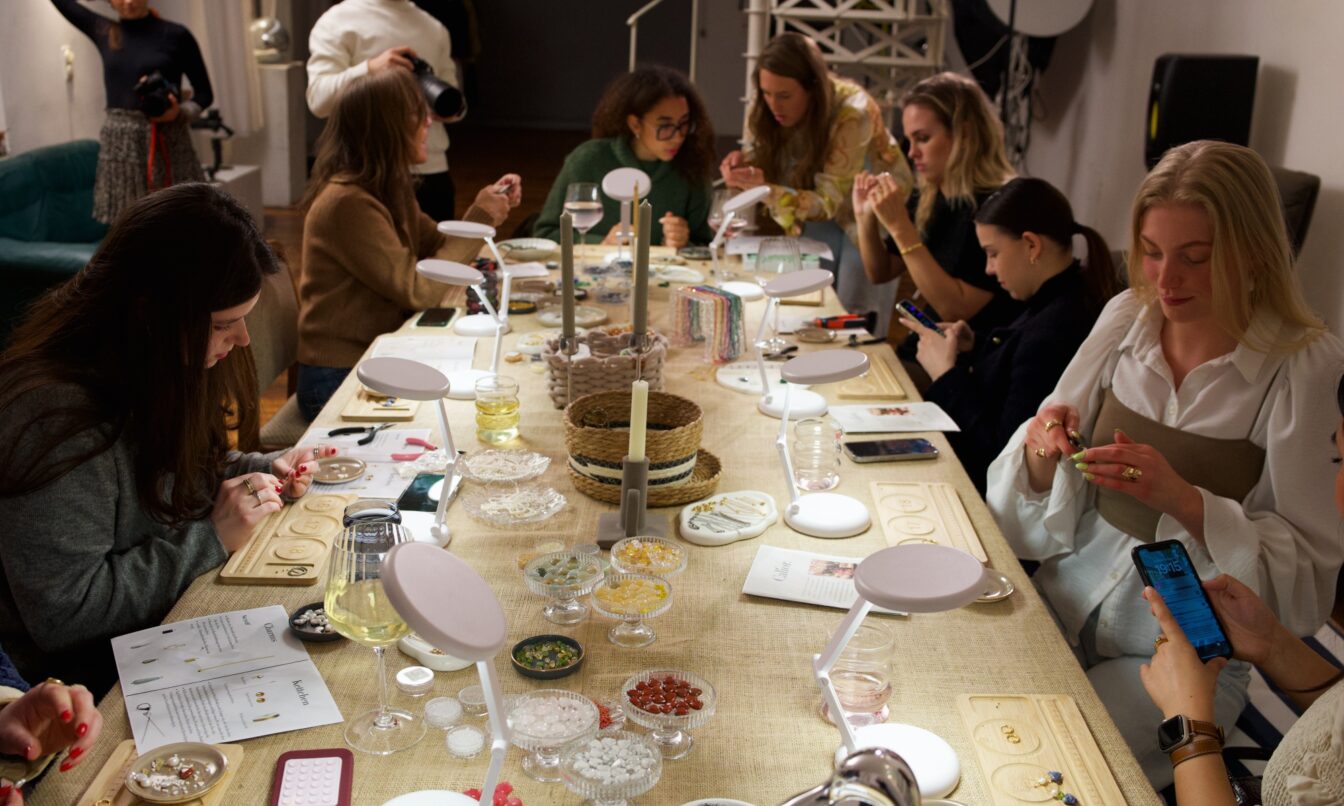 Teilnehmerinnen sitzen an einem Tisch bei einem Schmuckworkshop von Calior Jewelry in Wien