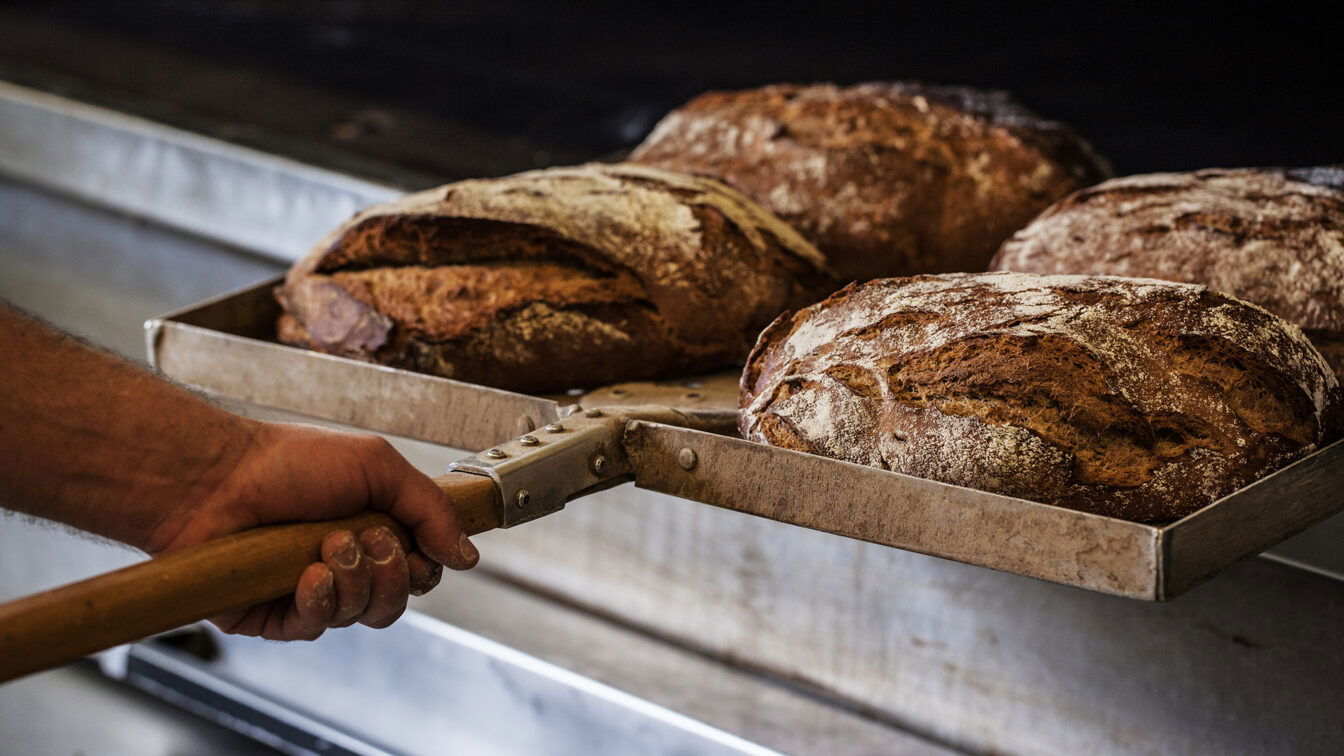(c) Hager Frisch gebackene Laibe Brot, die gerade aus dem Ofen geholt werden