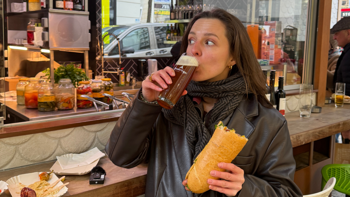 (c) Lena Müllner | 1000things Frau mit Bier und Hot Dog beim Wiener Würstelstand