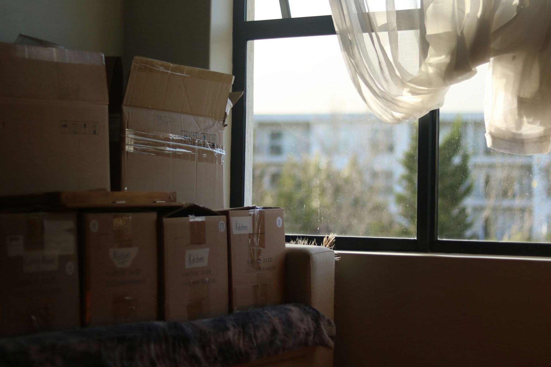 Umzugskisten in Wohnung vor Fenster