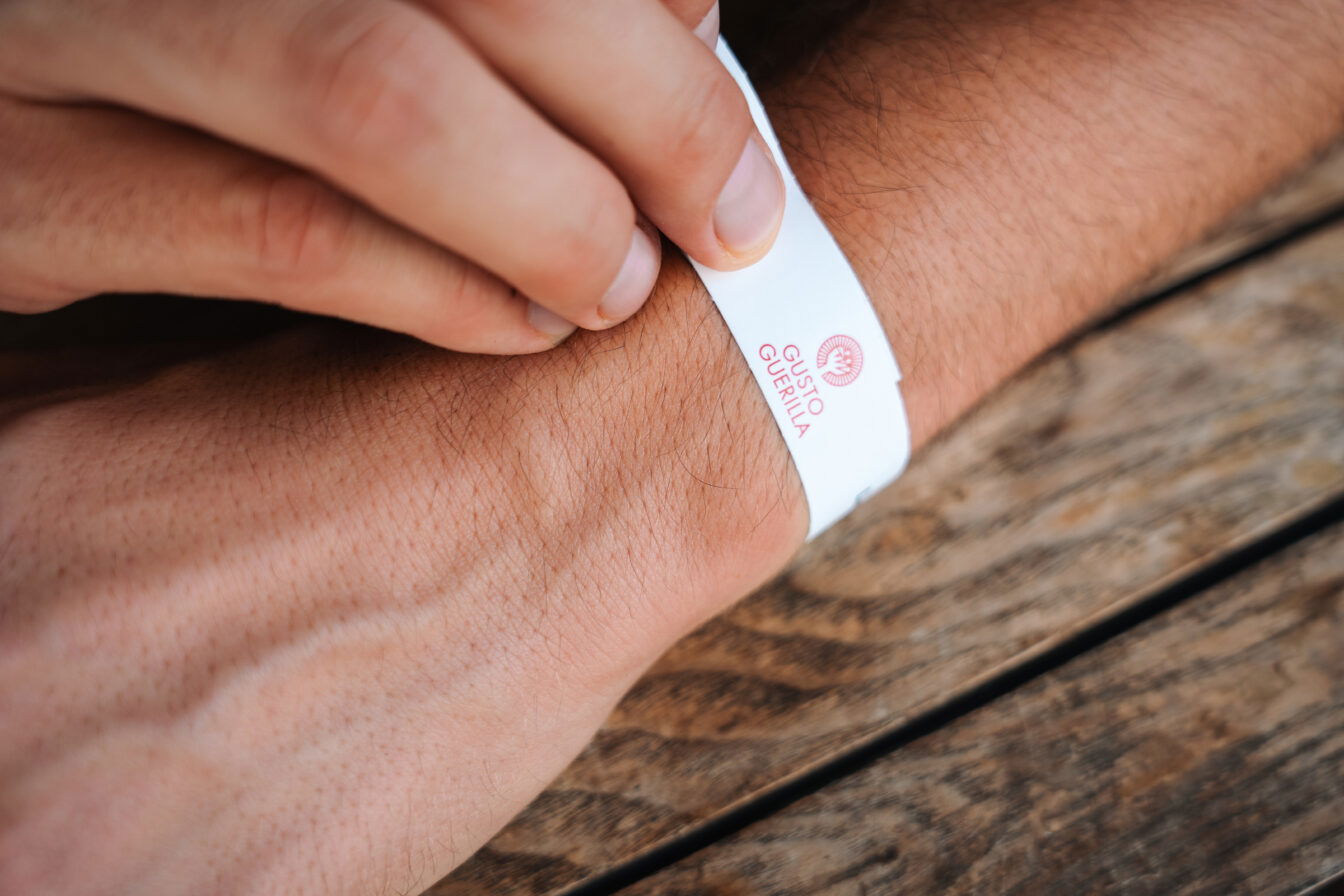 das Festivalband zur Gusto Guerilla 1000things-Tour am Handgelenk eines Menschen