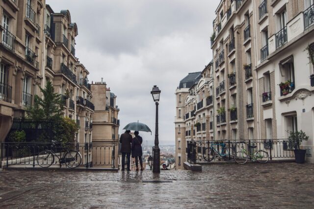 Regen in Paris, ein Paar unterm Regenschirm von Hinten.