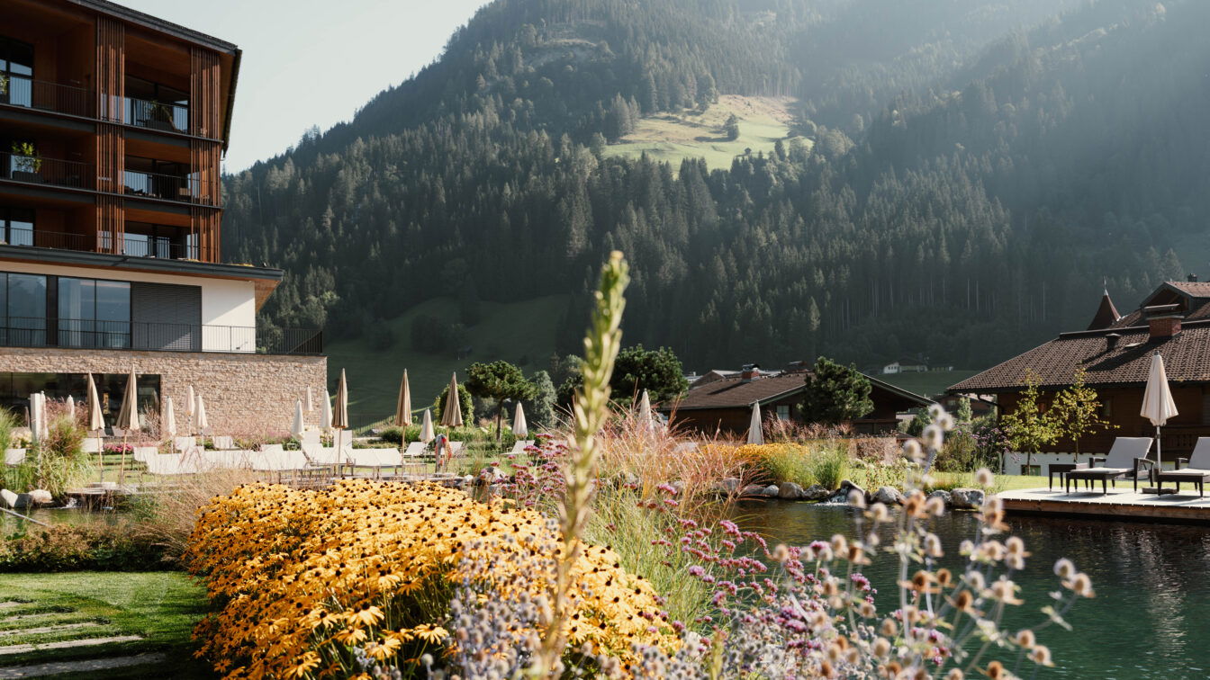 (c) Nesslerhof Familienfreundliches Hotel in den österreichischen Alpen mit Naturpool, gemütlicher Sonnenterrasse und blühendem Sommergarten – ideal für einen entspannten Familienurlaub in der Natur