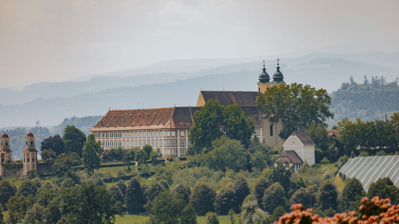 (c) Schilcherland Steiermark | Lupi Spuma Historisches Kloster Stainz im Schilcherland in der Steiermark, eingebettet in grüne Hügel und Weinberge mit Blick auf die malerische Landschaft der Südweststeiermark.