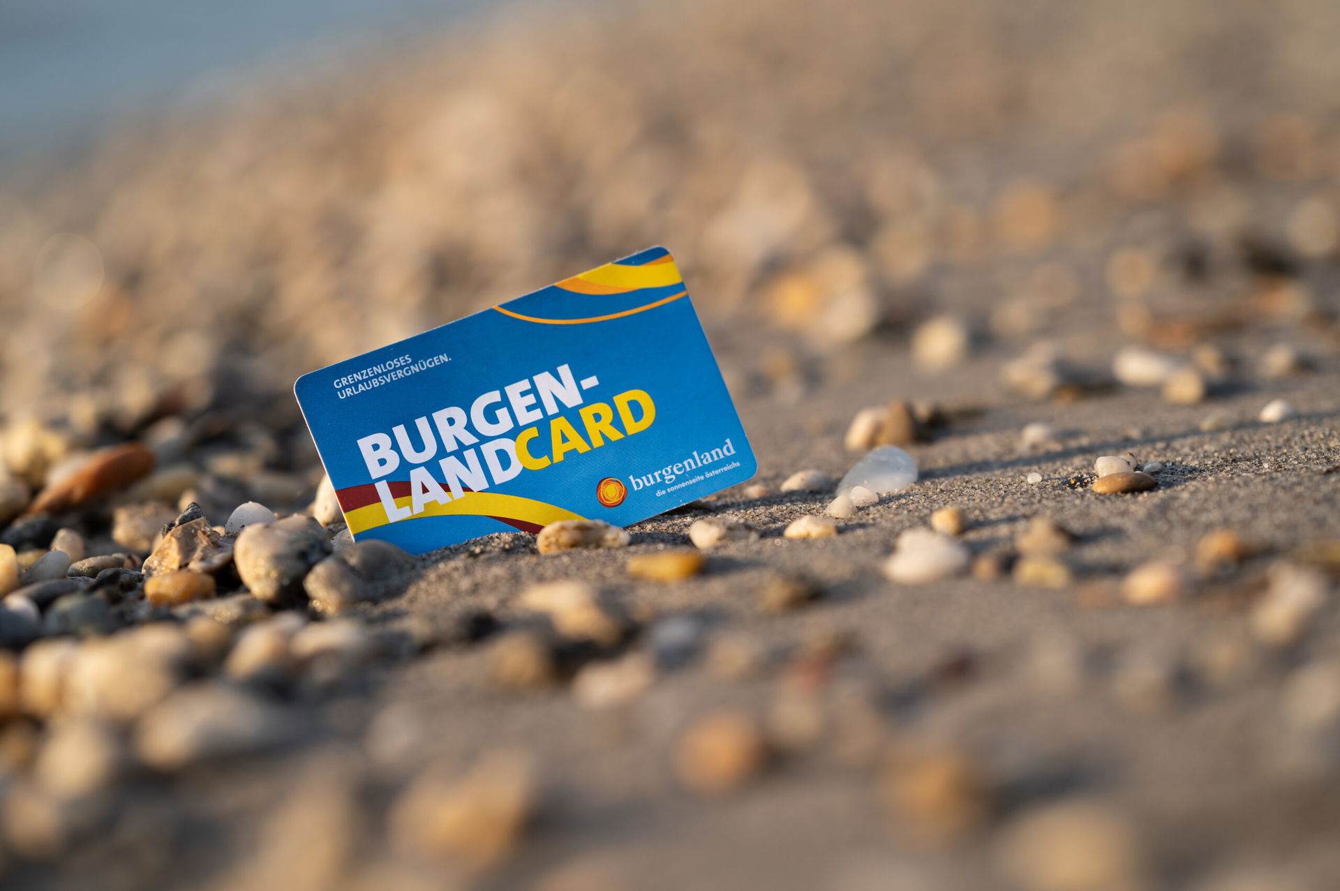 Die Burgenland Card steckt im Kiesstrand vom Neusiedler See