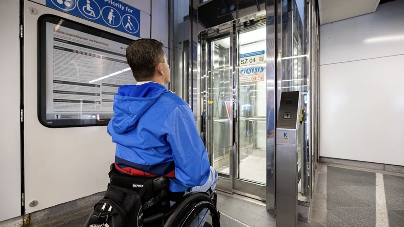 (c) Wiener Linien | Max Döringer Ein Mann im Rollstuhl vor einem Aufzug in einer U-Bahn-Station in Wien.