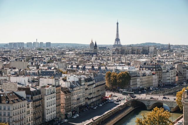 (c) Alexander Kagan | Unsplash Die Skyline einer Stadt bei schönem, sonnigen Wetter, mit Blick auf der Eiffelturm in Paris.