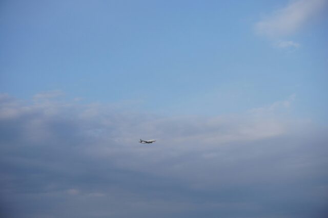 (c) Reed Lee | unsplash Flugzeug einer Billigfluglinie beim Landeanflug vor bewölktem Himmel – Symbolbild für günstiges Fliegen und versteckte Zusatzkosten bei Low-Cost-Airlines.