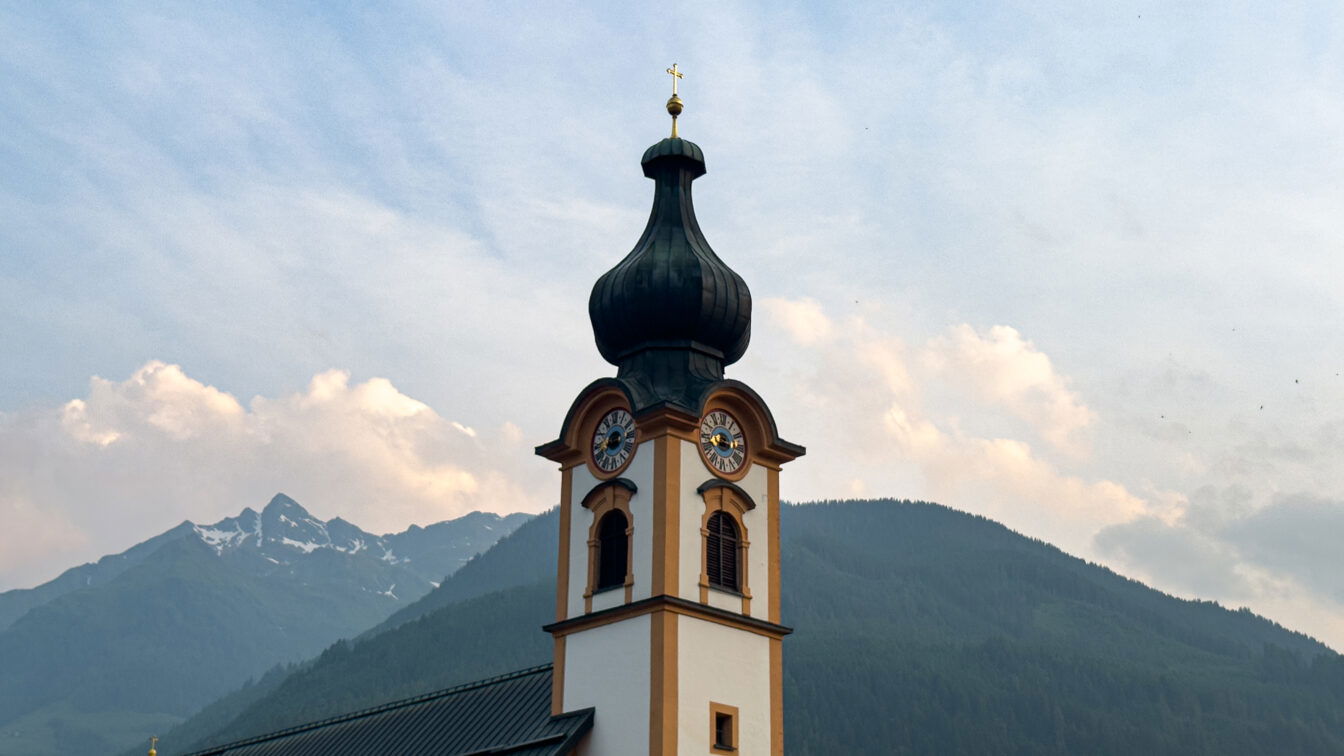 Kirchturm vor Bergpanorama