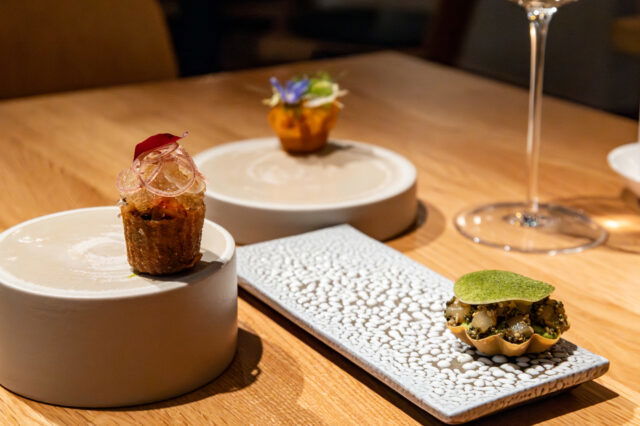 Fein angerichtete kleine Gourmetgerichte auf modernen Keramiktellern in elegantem Restaurantambiente in in Prenzlauer Berg in Berlin.