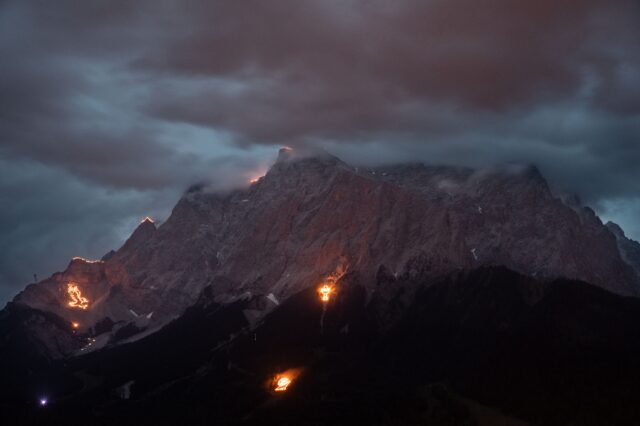 (c) Sonnwendfeuer Zugspitzarena | Tirol Werbung, Soulas Oliver Spektakuläres Sonnwendfeuer in der Tiroler Zugspitz Arena – leuchtende Bergfeuer und mystische Stimmung rund um die Zugspitze bei Nacht, traditionsreiches Schauspiel in den Alpen.