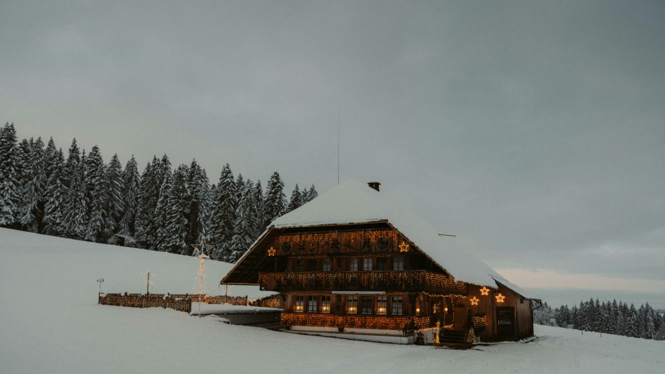 (c) Troy Qian | Unsplash Hütte mit Schnee in den Bergen