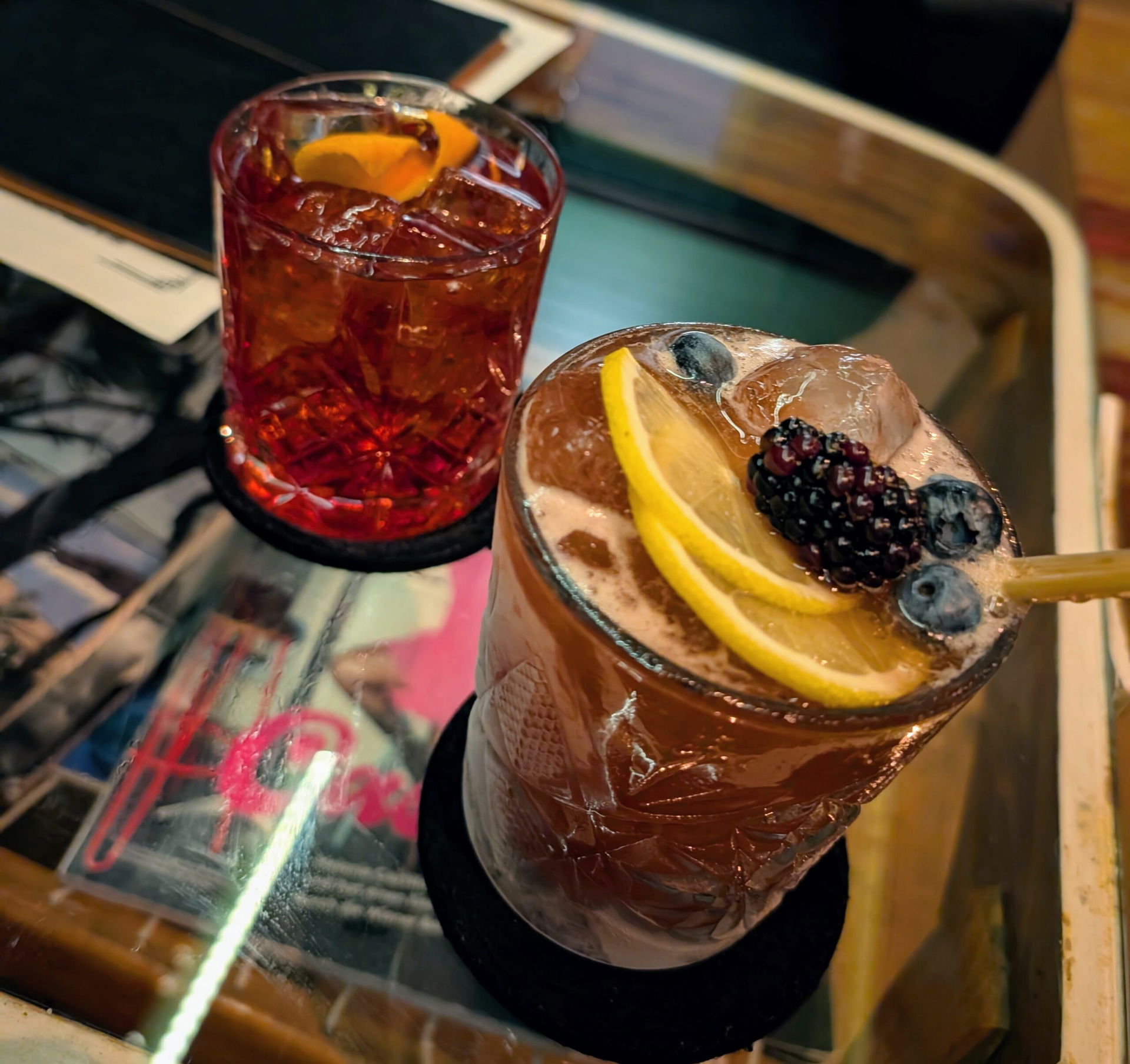 zwei Cocktails stehen auf einem Glastisch in der Bar Pani in Wien