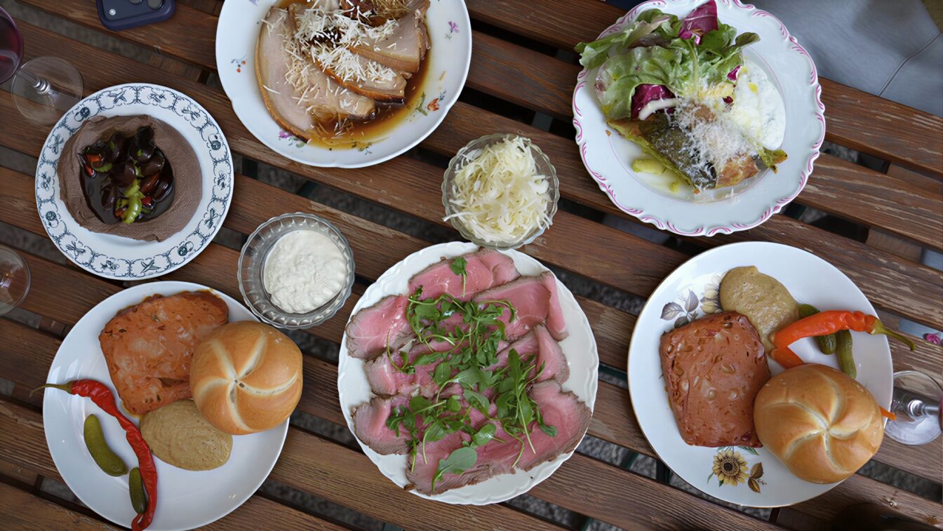 ein mit Heurigen-Gerichten gedeckter Tisch beim Weingut Zum Pranger in Gumpoldskirchen