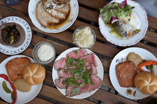 ein mit Heurigen-Gerichten gedeckter Tisch beim Weingut Zum Pranger in Gumpoldskirchen