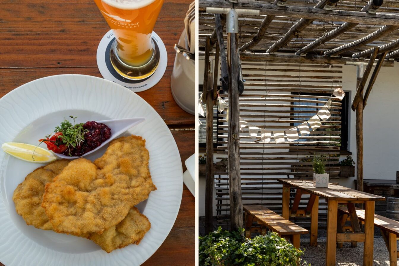 Links ist ein Teller mit knusprigem Wiener Schnitzel, Preiselbeeren, einem Zitronenstück und frischer Kresse zu sehen. Dazu steht ein Glas helles Weißbier auf einem Holz-Biertisch. Rechts daneben ist ein sonniger Biergarten mit rustikalem Holztisch, Bänken und einer Pergola aus Holzlatten zu erkennen. An einem Topf mit Pflanze ist die Tischnummer 219 befestigt. Die Szene vermittelt gemütliche, bayerische Wirtshaus-Atmosphäre im Garmischer Hof in Garmisch-Partenkirchen.