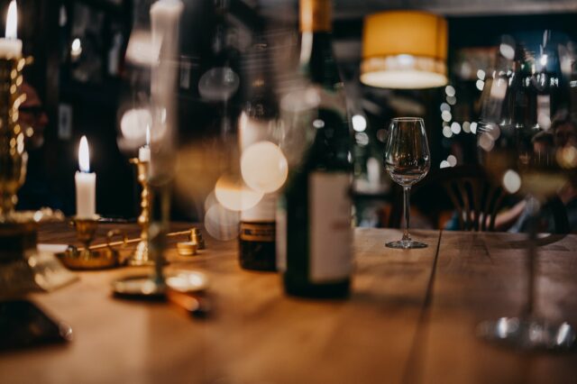 Holztisch mit gläsern und einer Flasche Rotwein