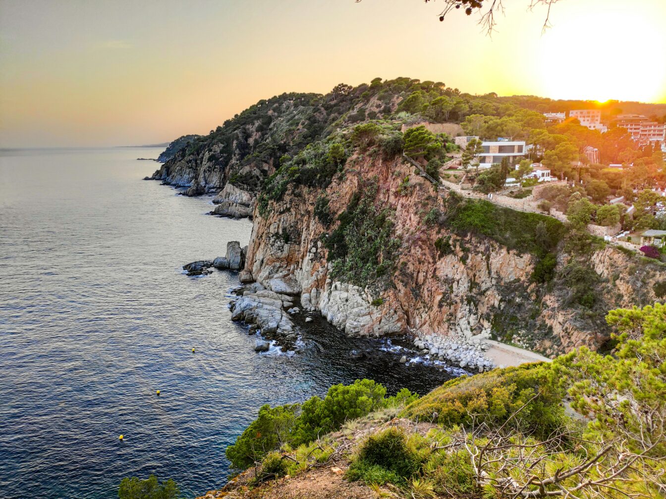 Costa Brava bei Sonnenuntergang: Klippen und Wälder mit Blick auf das blaue Meer.