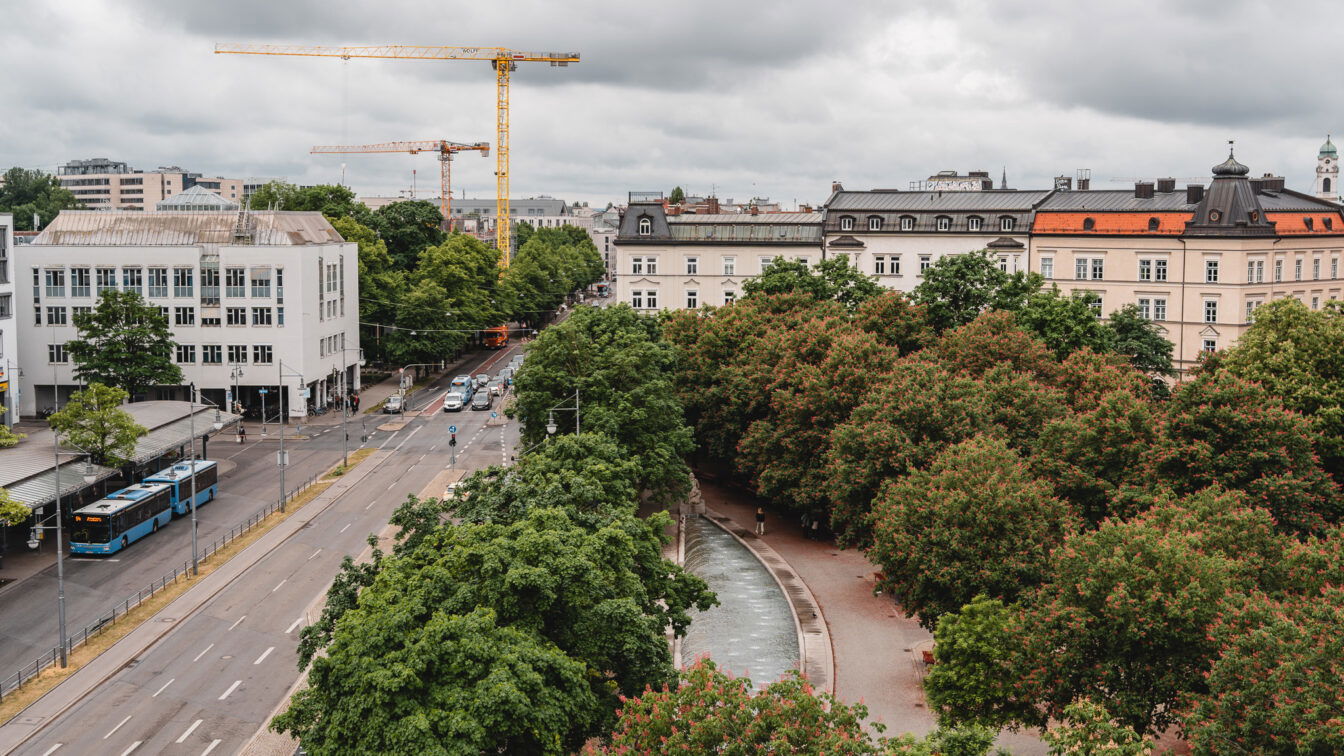 (c) Lilli Wermuth | 1000things Blick von oben auf einen begrünten Platz am Münchner Ostbahnhof bei Regen.