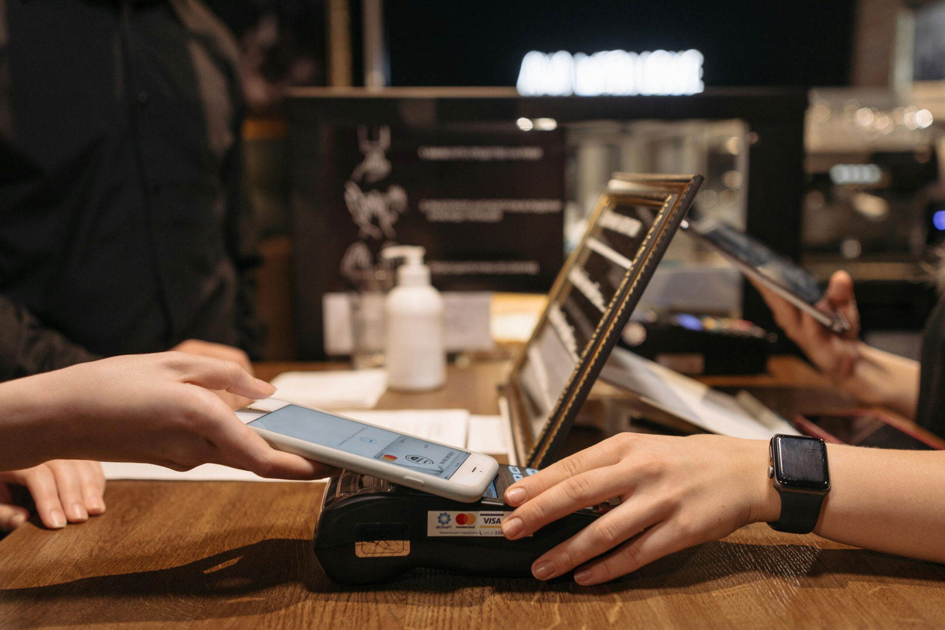 Person bezahlt im restaurant mit dem handy