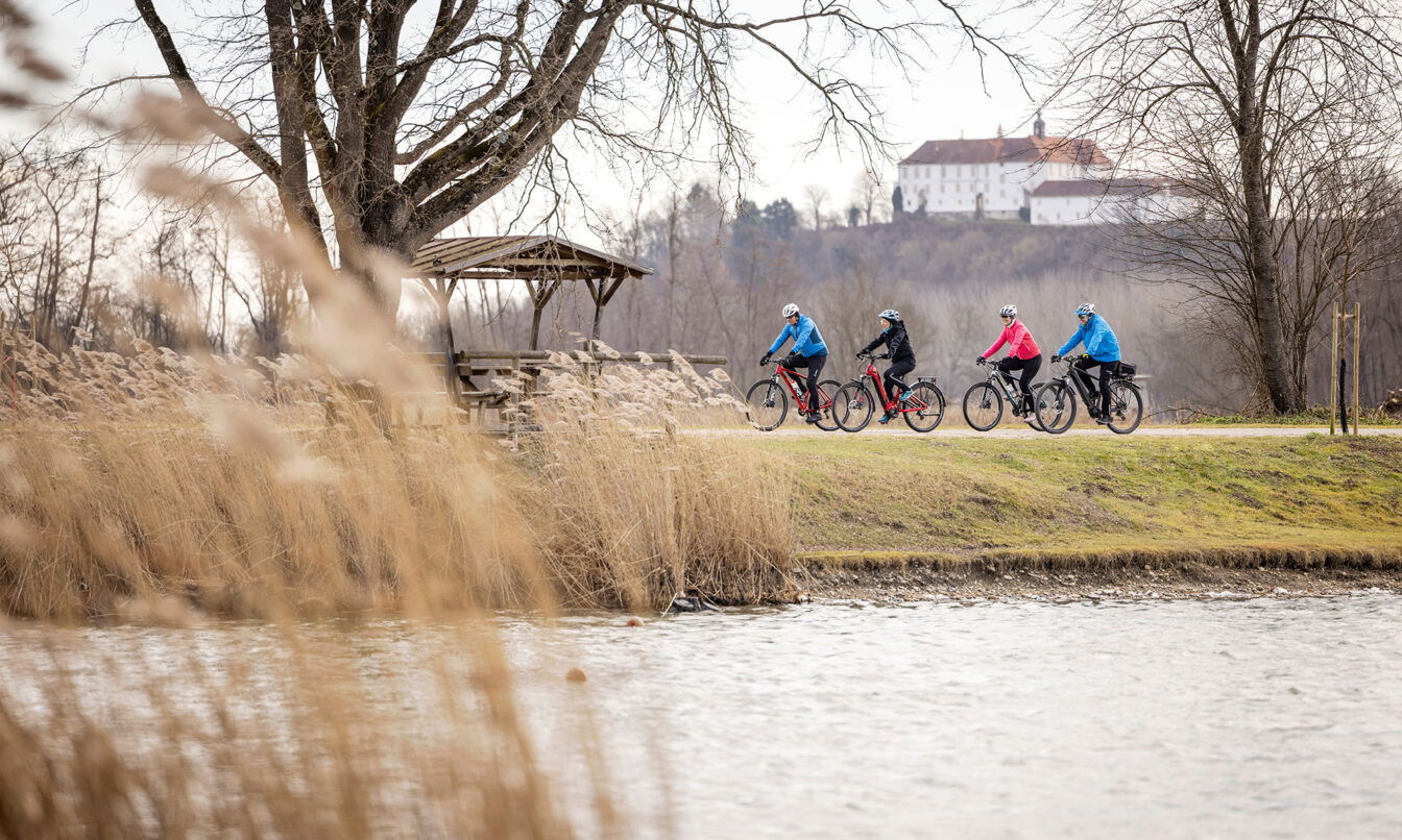 Vier Personen fahren mit dem Fahrrad durch die Winterlandschaft im Thermen- & Vulkanland.