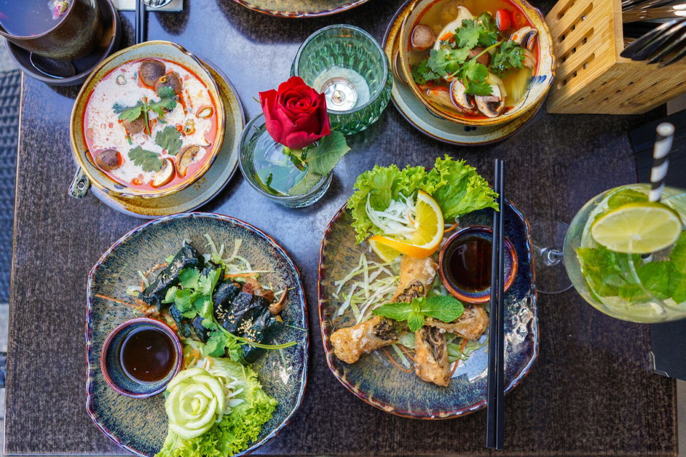 Ein bunt gedeckter Tisch von oben mit asiatischen Gerichten.