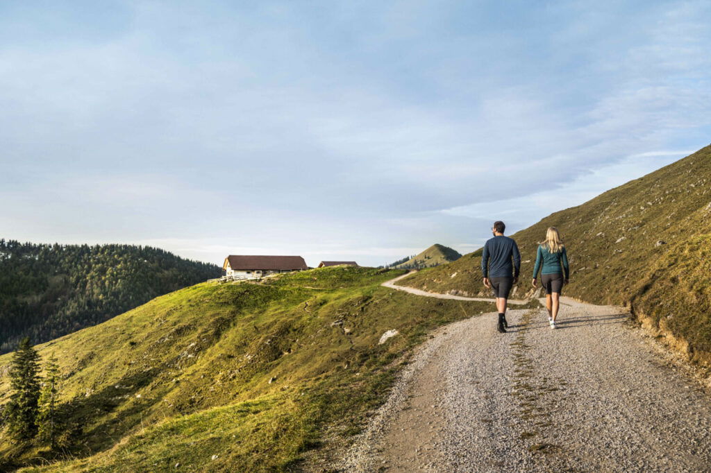 Ein Mann und eine Frau wandern im Herbst durch Oberbayern.