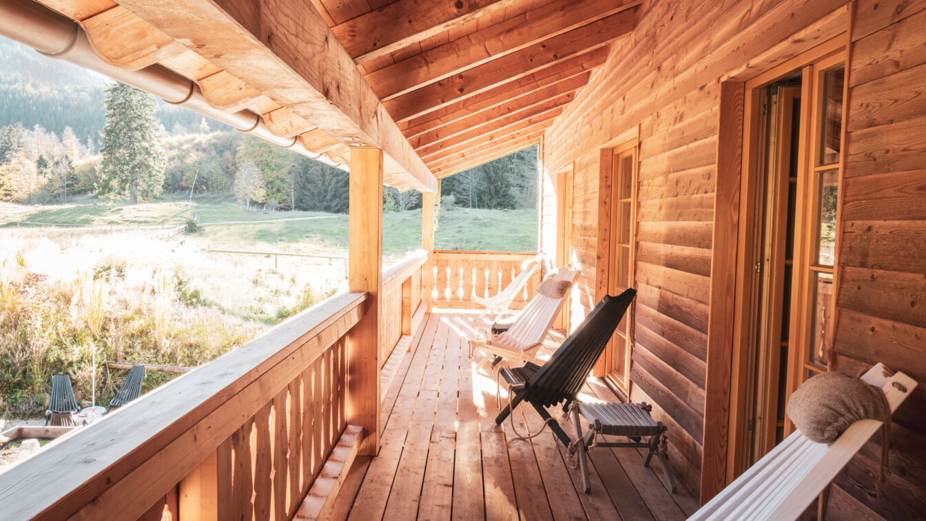 (c) Daniel Breidt Gemütliche Holzveranda mit Liegestühlen in einer Berghütte in den Alpen bei Sonnenschein.