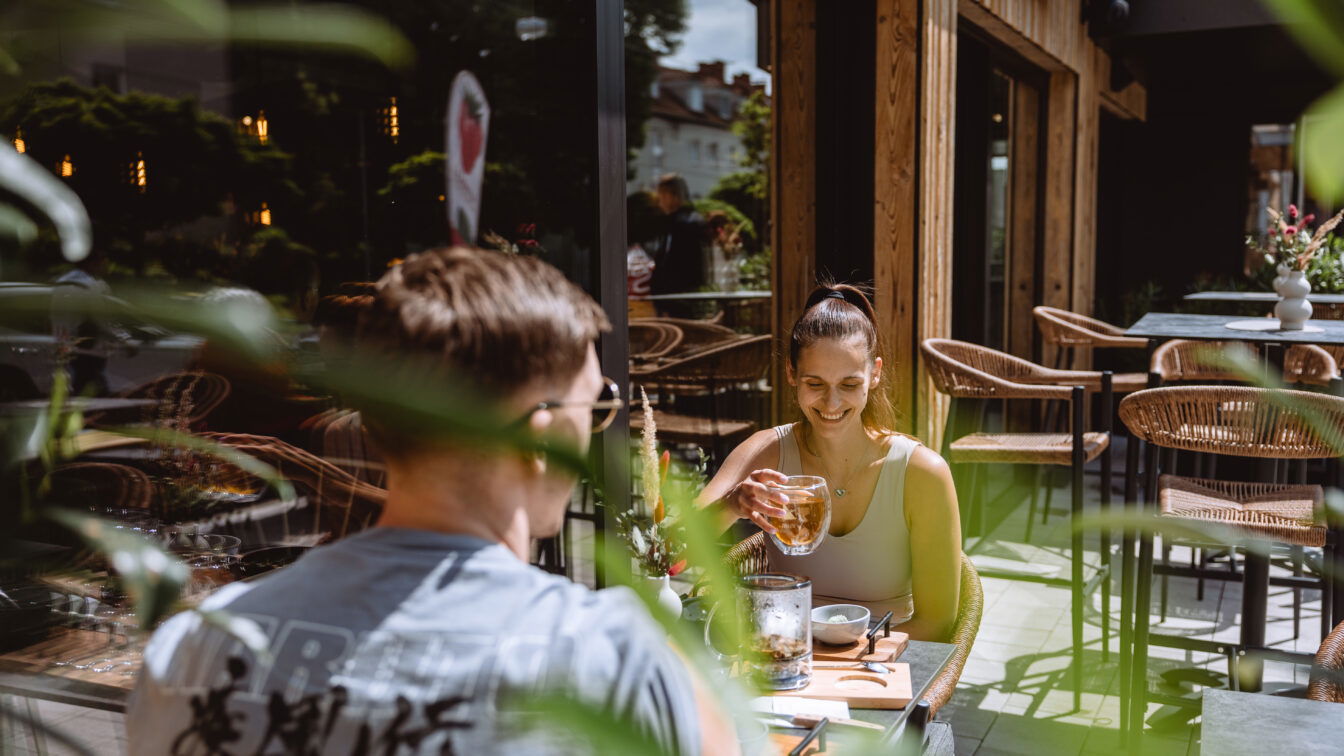 (c) Lehner Beeren Zwei Menschen auf einer Terrasse, die begrünt und sonnig ist.