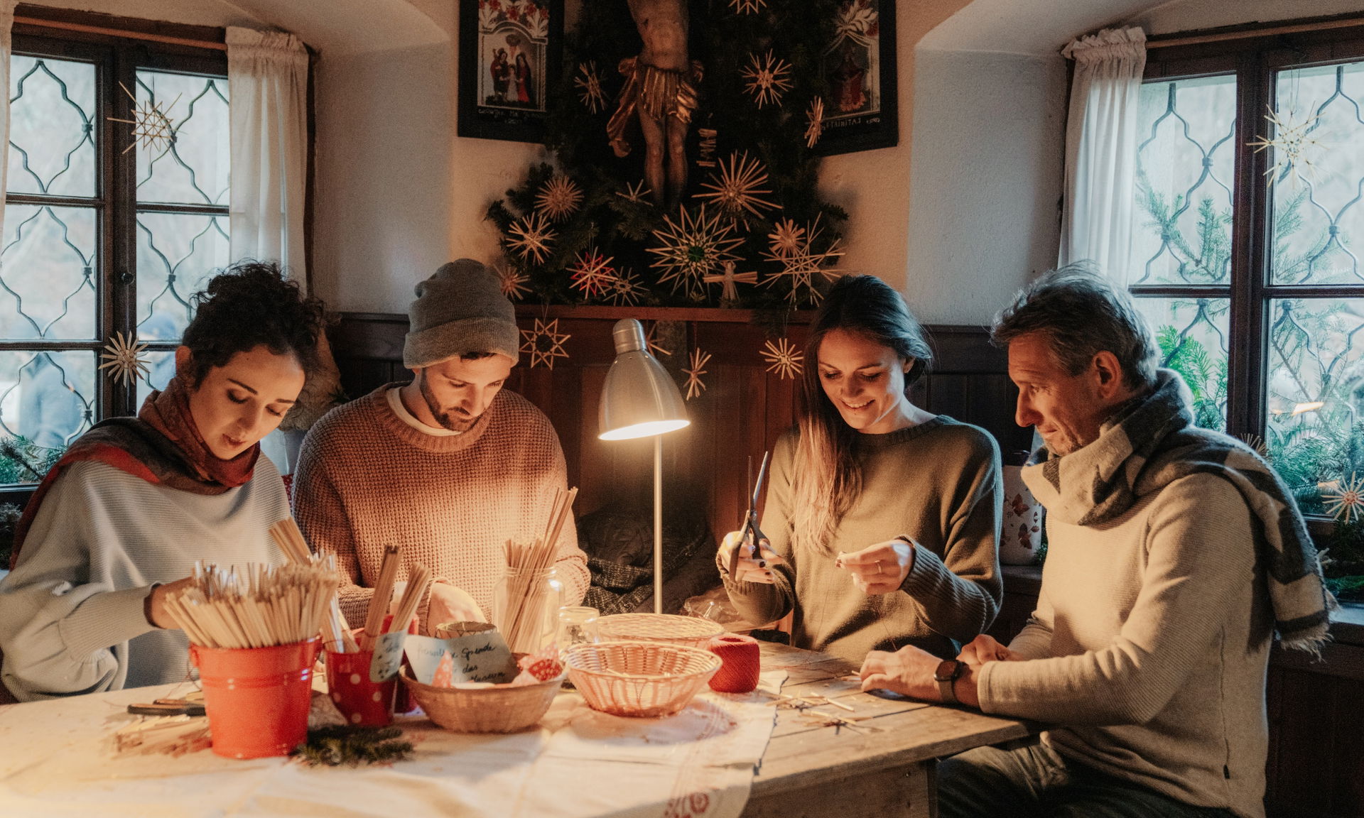Vier Menschen basteln am Tisch beim Advent im Österreichischen Freilichtmuseum Stübing.