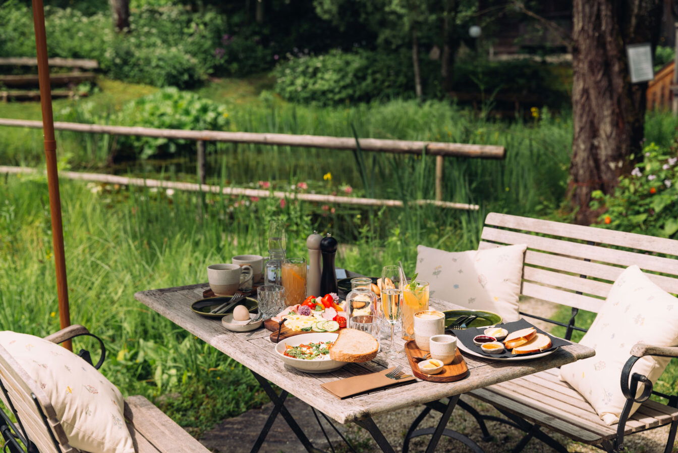Ein gedeckter Frühstückstisch in sommerlichem Ambiente