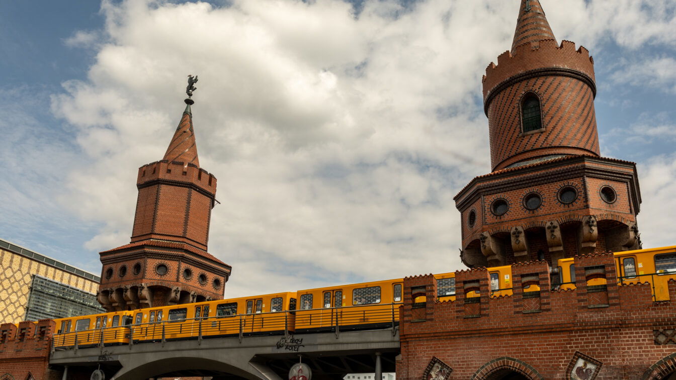 (c) Sonja Koller | 1000things Gelbe Berliner U-Bahn fährt über die historische Oberbaumbrücke im Stadtteil Friedrichshain, Wahrzeichen und Sehenswürdigkeit in Berlin.