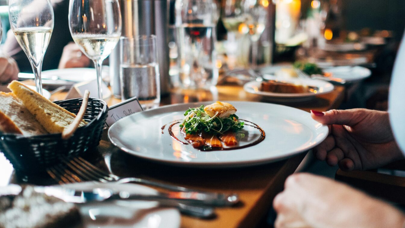 Ein gedeckter Tisch mit Weingläsern und einem Fine Dining Teller.