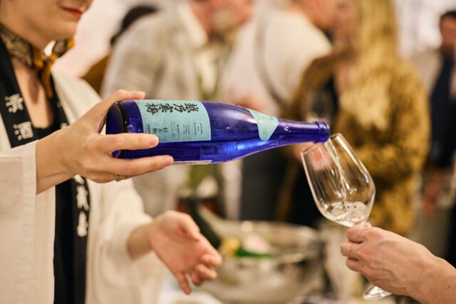 Sake wird aus einer Flasche in ein Glas ausgeschenkt