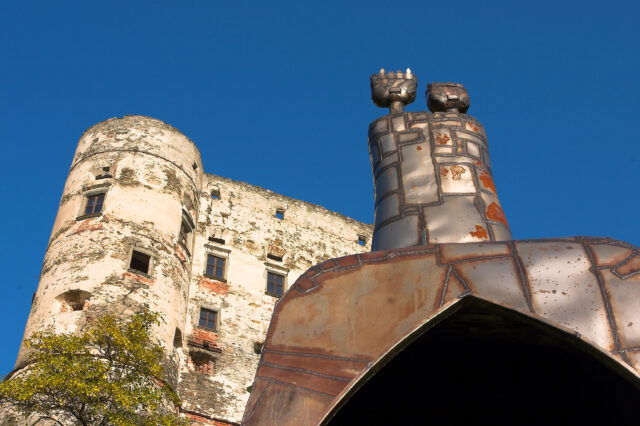 Alte Burg in der Künstlerstadt Gmünd mit moderner Metallskulptur im Vordergrund vor blauem Himmel