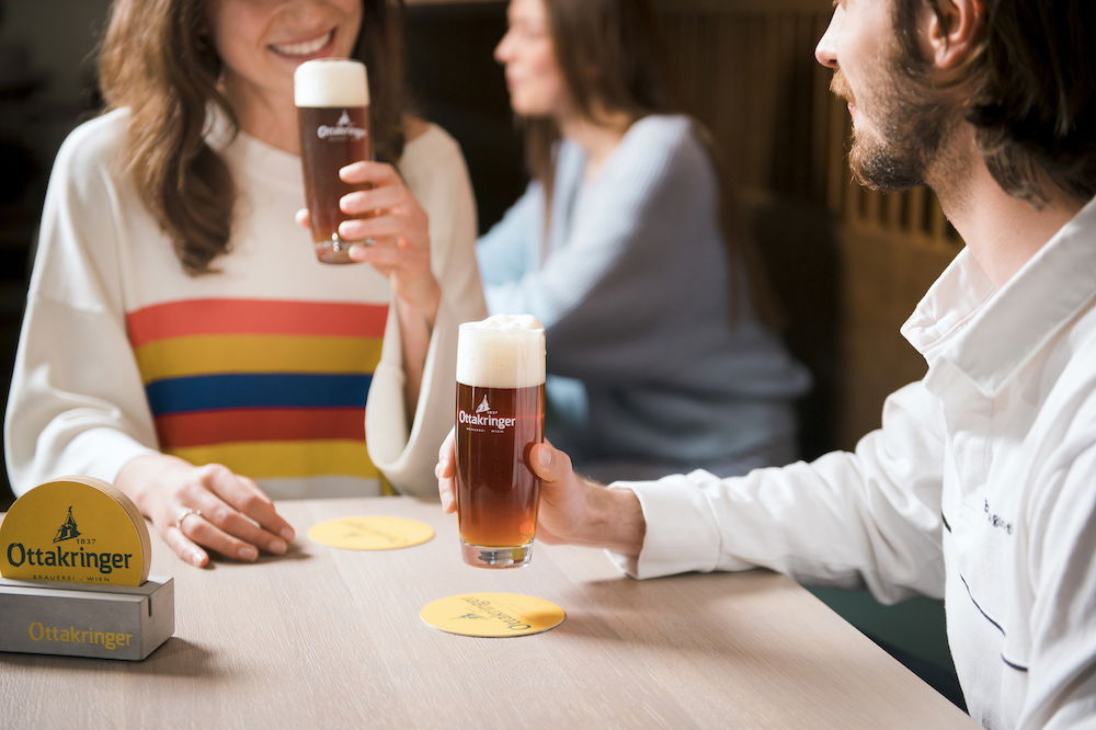 Zwei Personen stoßen mit Ottakringer Bier an