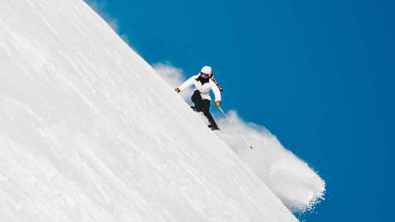 (c) Nicolai Berntsen | Unsplash Skifahren in Bayern auf einer steilen Piste bei strahlend blauem Himmel – perfekte Wintersportbedingungen in beliebten Skigebieten wie Garmisch-Partenkirchen, Spitzingsee oder Sudelfeld, die bequem mit den Öffentlichen Verkehrsmitteln erreichbar sind.