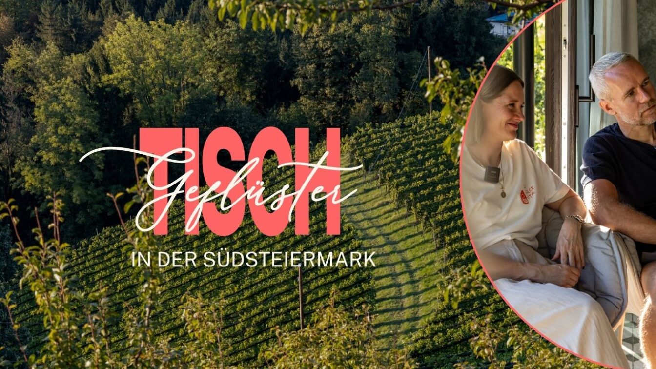 Bild mit dem Schriftzug ‚Tischgeflüster in der Südsteiermark‘ vor einer grünen Weinberg-Landschaft. Rechts im Bild sitzen eine Frau und ein Mann nebeneinander und unterhalten sich entspannt.