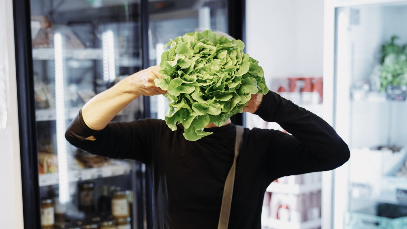 Person mit Salat vor dem Gesicht - im Mila Mitmachsupermarkt Wien