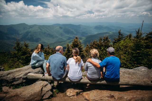 mehrere Generationen einer Familie beim gemeinsamen Wandern in den Bergen
